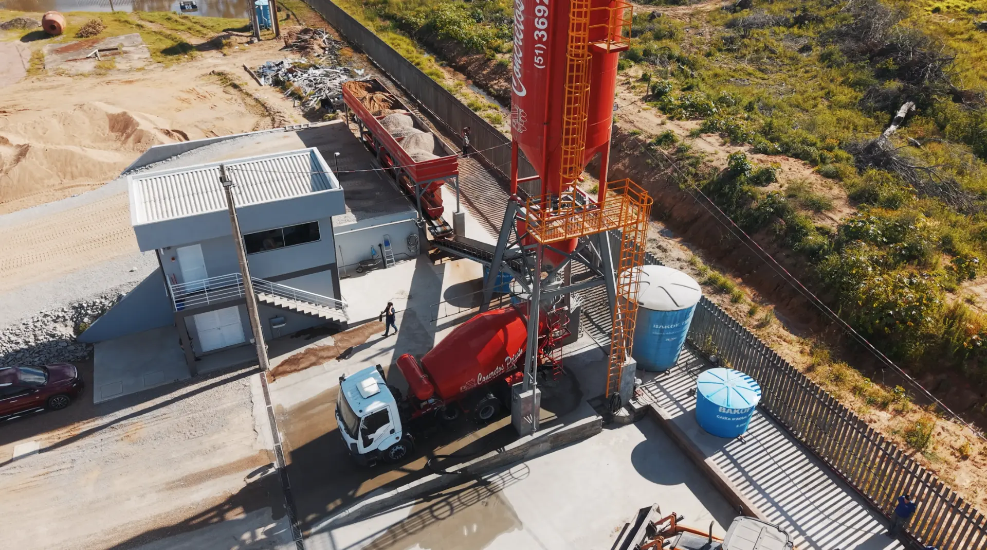 Central dosadora com silo de cimento e caminhão betoneira em carregamento