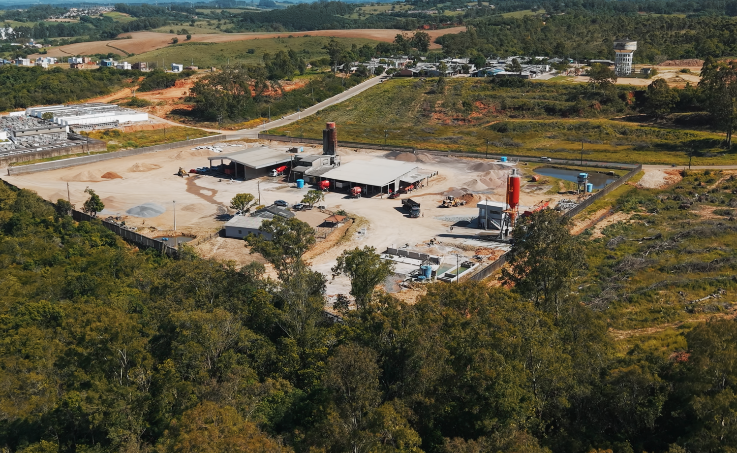 Vista aérea do parque industrial da Concretos Peixoto com silos e baias de agregados