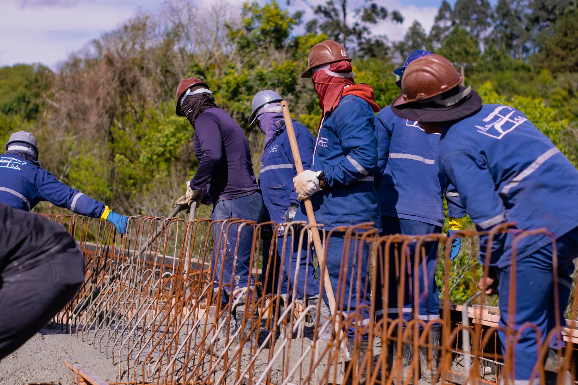 Operários trabalhando na armação e no acabamento do concreto