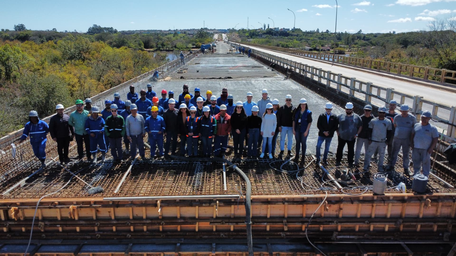 Equipe reunida sobre a estrutura concretada da ponte